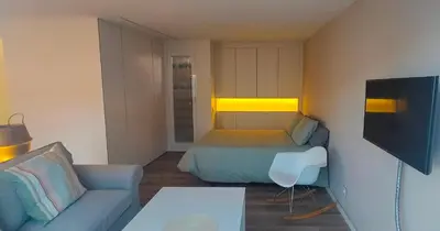 a small bedroom with a bed and a couch at LOFT CON TERRAZA en el centro de Santiago de Compostela VUTCO 07320 in Santiago de Compostela