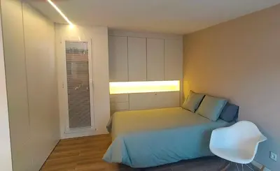 a bedroom with a bed and a window and a chair at LOFT CON TERRAZA en el centro de Santiago de Compostela VUTCO 07320 in Santiago de Compostela