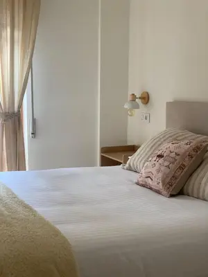 a white bed with a pillow and a window at Pensión Cantabrico in Navia