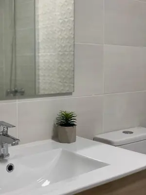 a white bathroom with a sink and a potted plant at Pensión Cantabrico in Navia