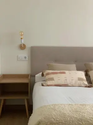 a bedroom with a white bed with a nightstand and a bed sidx sidx sidx at Pensión Cantabrico in Navia