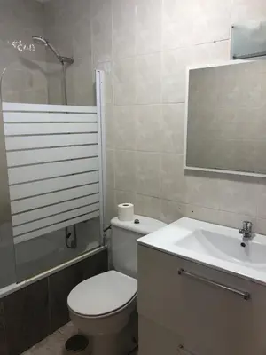 a bathroom with a toilet and a sink and a mirror at Pensión Cantabrico in Navia