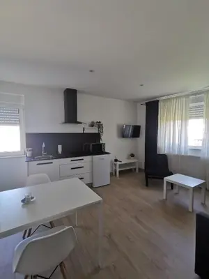 a kitchen and living room with a table and chairs at Apartamentos Seijo in Villalba