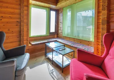 a room with two chairs and a table and two windows at Cabañas El Ruso in Galende