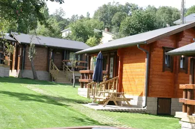 a log cabin with an umbrella on the side of it at Cabañas El Ruso in Galende