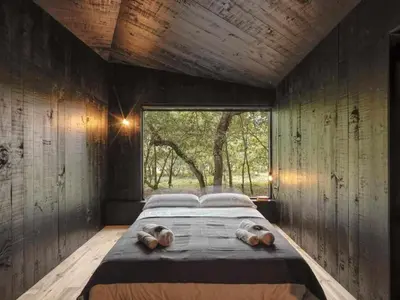 a bedroom with a large bed with a large window at A Leira 116 Cabañas de diseño in Sarria