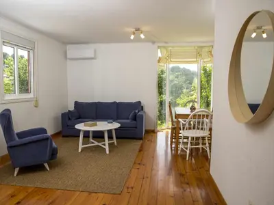 a living room with a blue couch and a table at A Casiña - Casa Rural en la Ribeira Sacra, Galicia in Ourense