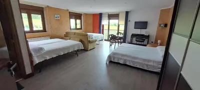 a room with two beds and a living room at Casa Buda Conors & Spa Boutique in Foz