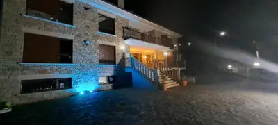 a building with blue lights on the side of it at night at Casa Buda Conors & Spa Boutique in Foz