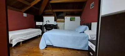 a bedroom with two beds and a desk in it at Casa Buda Conors & Spa Boutique in Foz