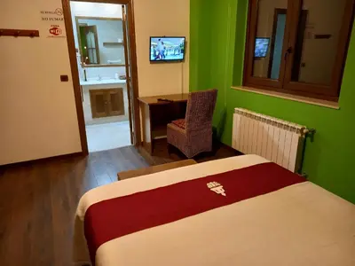 a room with a bed and a desk and a television at Casa Buda Conors & Spa Boutique in Foz