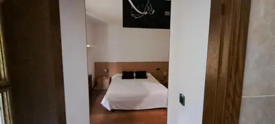 a bedroom with a bed with white sheets and black pillows at Casa Buda Conors & Spa Boutique in Foz