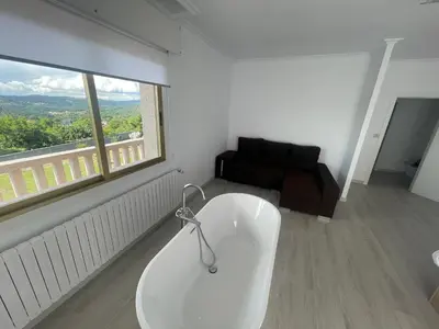 a white bath tub in a room with a window at LA RATONERA in Podentes
