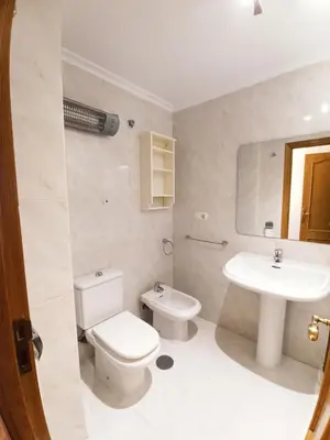 a white bathroom with a toilet and a sink at Ría de Viveiro in Vivero