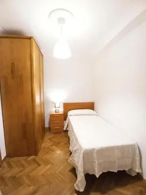 a bedroom with a bed and a wooden cabinet at Ría de Viveiro in Vivero