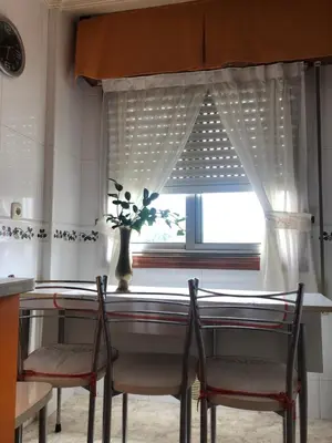 a dining room table with two chairs and a window at FIFA in Arzúa