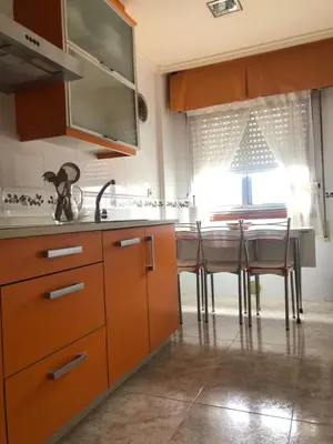 a kitchen with wooden cabinets and a table with chairs at FIFA in Arzúa