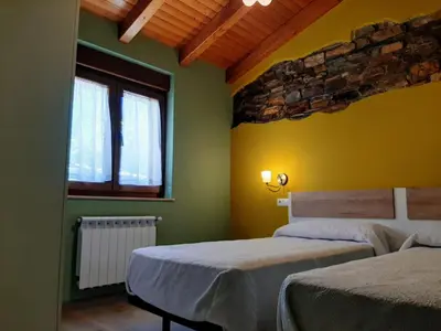 a bedroom with two beds and two windows at Vivienda Turistica in Coto