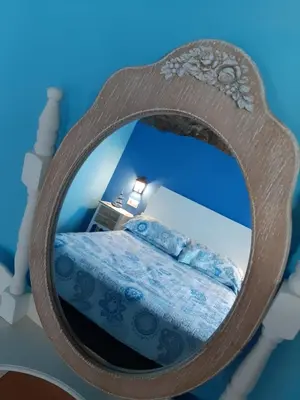 a mirror reflecting a bed in a blue room at Vivienda Turistica in Coto