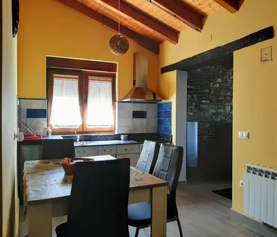 a kitchen with a table and chairs in a room at Vivienda Turistica in Coto