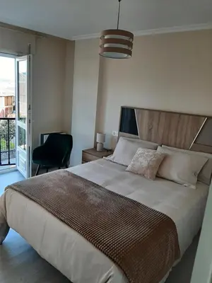 a bedroom with a large bed and a chair at Vial Sol in Viveiro