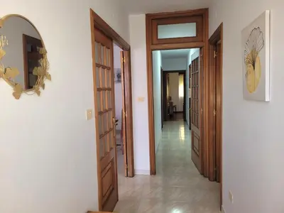 a hallway with two wooden doors and a mirror at PIso de 3 habitaciones en centro de Miño in Miño