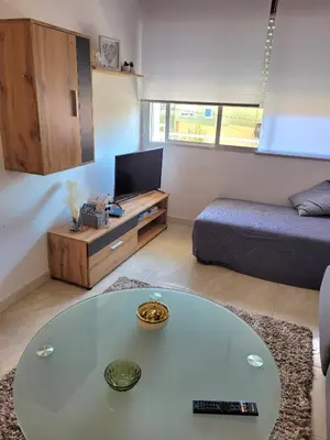 a living room with a glass table and a bed at PIso de 3 habitaciones en centro de Miño in Miño
