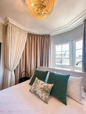 a bedroom with a large bed with a chandelier at PENSIÓN CALDEA in Caldas de Reis