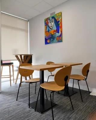 a table and chairs with a painting on the wall at Siaba Pensión Boutique in Sigüeiro