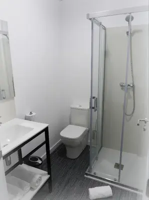 a bathroom with a toilet and a glass shower at Siaba Pensión Boutique in Sigüeiro