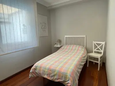 a small bedroom with a bed and a chair at Apartamento A Tenencia in Sada