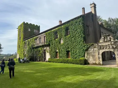 a building covered in ivy with people walking around it at Apartamento A Tenencia in Sada