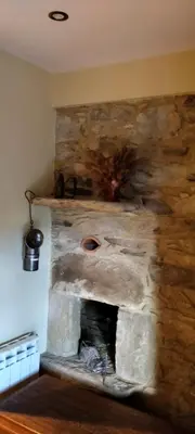 a stone fireplace in the corner of a room at Casa de Aldea El Boje in Faedo