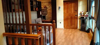 a hallway with a staircase and a wooden door at Casa de Aldea El Boje in Faedo