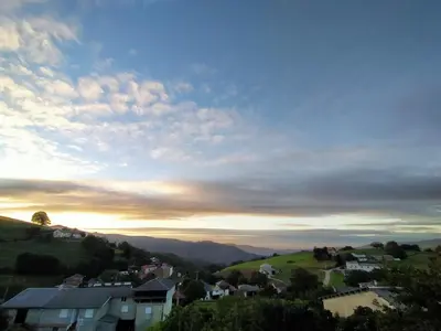 a view of a town with the sunset in the sky at Casa de Aldea El Boje in Faedo