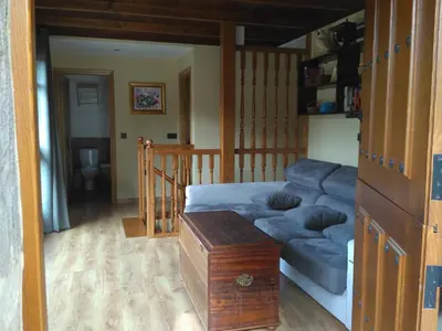 a living room with a blue couch and a table at Casa de Aldea El Boje in Faedo