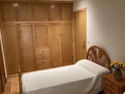a bedroom with a bed and a wooden cabinet at Casa do Corredor in Chantada