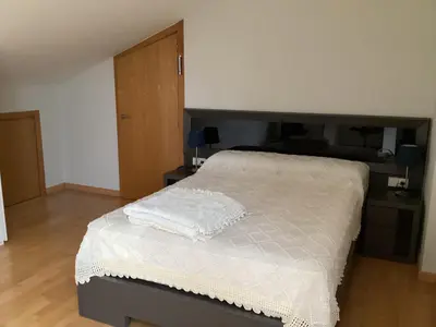 a bedroom with a large bed with a wooden floor at Casa do Corredor in Chantada