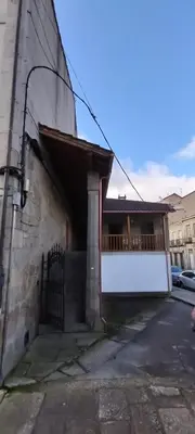 a building with a gate on the side of it at Casa do Corredor in Chantada