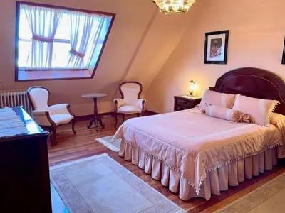 a bedroom with a bed and chairs and a window at The Cliffs - Milamarina in Viveiro
