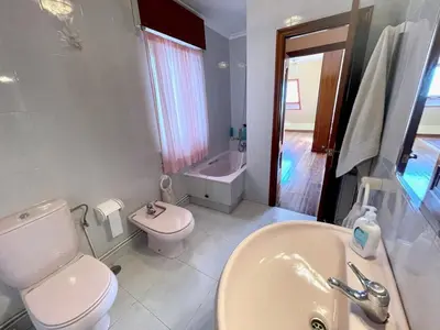 a white bathroom with a toilet and a sink at The Cliffs - Milamarina in Viveiro