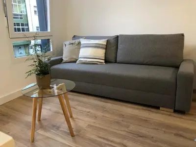 a bedroom with a bed and a table with a plant at Apartamentos CANDEA in Lugo