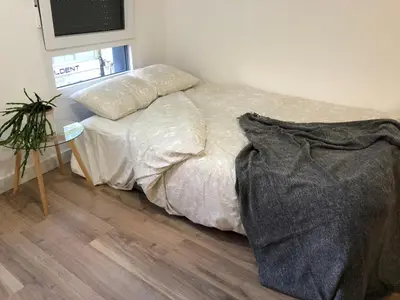a kitchen with white cabinets and a white table and chairs at Apartamentos CANDEA in Lugo