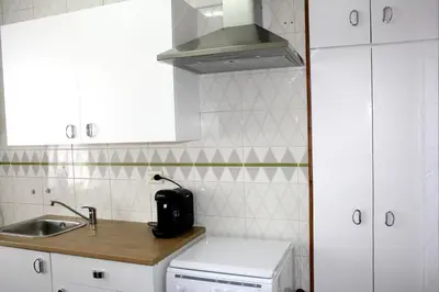 a kitchen with white cabinets and a sink at APARTAMENTO CÉNTRICO, AMPLIO y LUMINOSO in Guitiriz