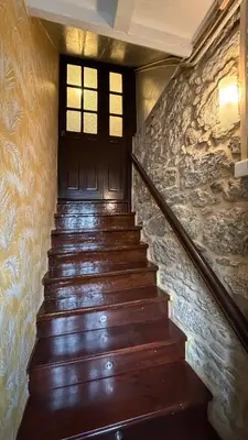 a stone wall next to a staircase with a stone stair case at APARTAMENTO CÉNTRICO, AMPLIO y LUMINOSO in Guitiriz
