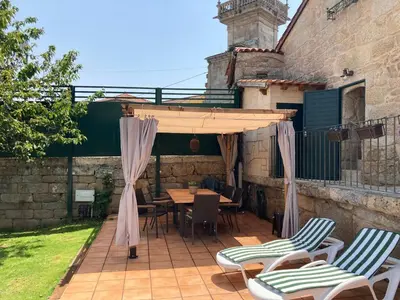 a patio with a table and chairs under a canopy at A casa da Ita in Ourense