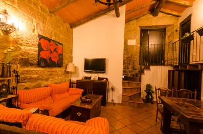 a living room with orange couches and a television at A casa da Ita in Ourense