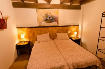 a bedroom with a bed with two night stands and two lamps at A casa da Ita in Ourense
