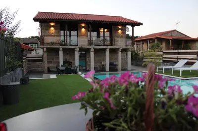 a house with a swimming pool and a house with flowers at CASA VACACIONAL ACIO in Ourense