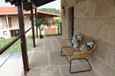 a wicker chair sitting on a patio at CASA VACACIONAL ACIO in Ourense
